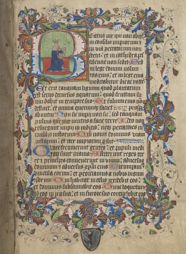 Lavishly decorated page with a historiated letter B, depicting a man wearing a crown and playing the harp. Most of the border is floral in blue, green, and red ink. The coat of arms at the bottom is a griffin-like creature in black ink.